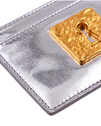 Schiaparelli Keyhole card holder in silver, detail close-up of the textured gold keyhole hardware and edge stitching