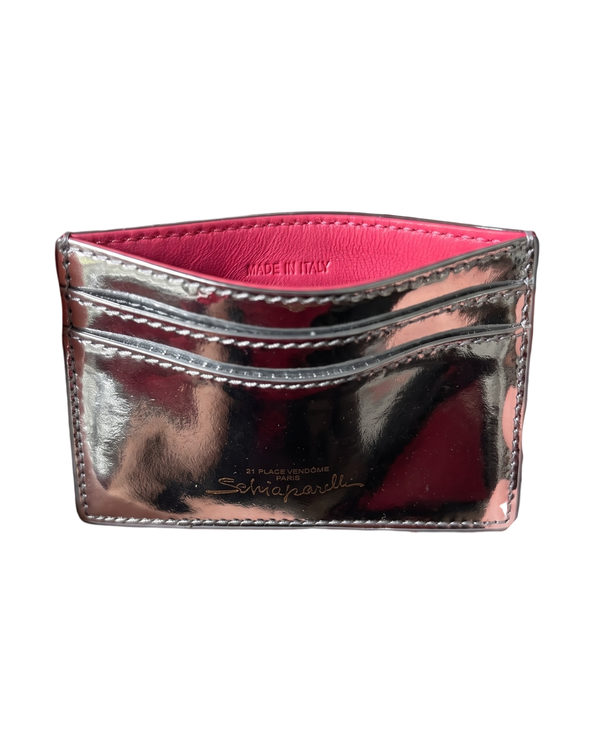 Schiaparelli Keyhole card holder in silver, angled back view with pink interior, two card slots and gold script logo