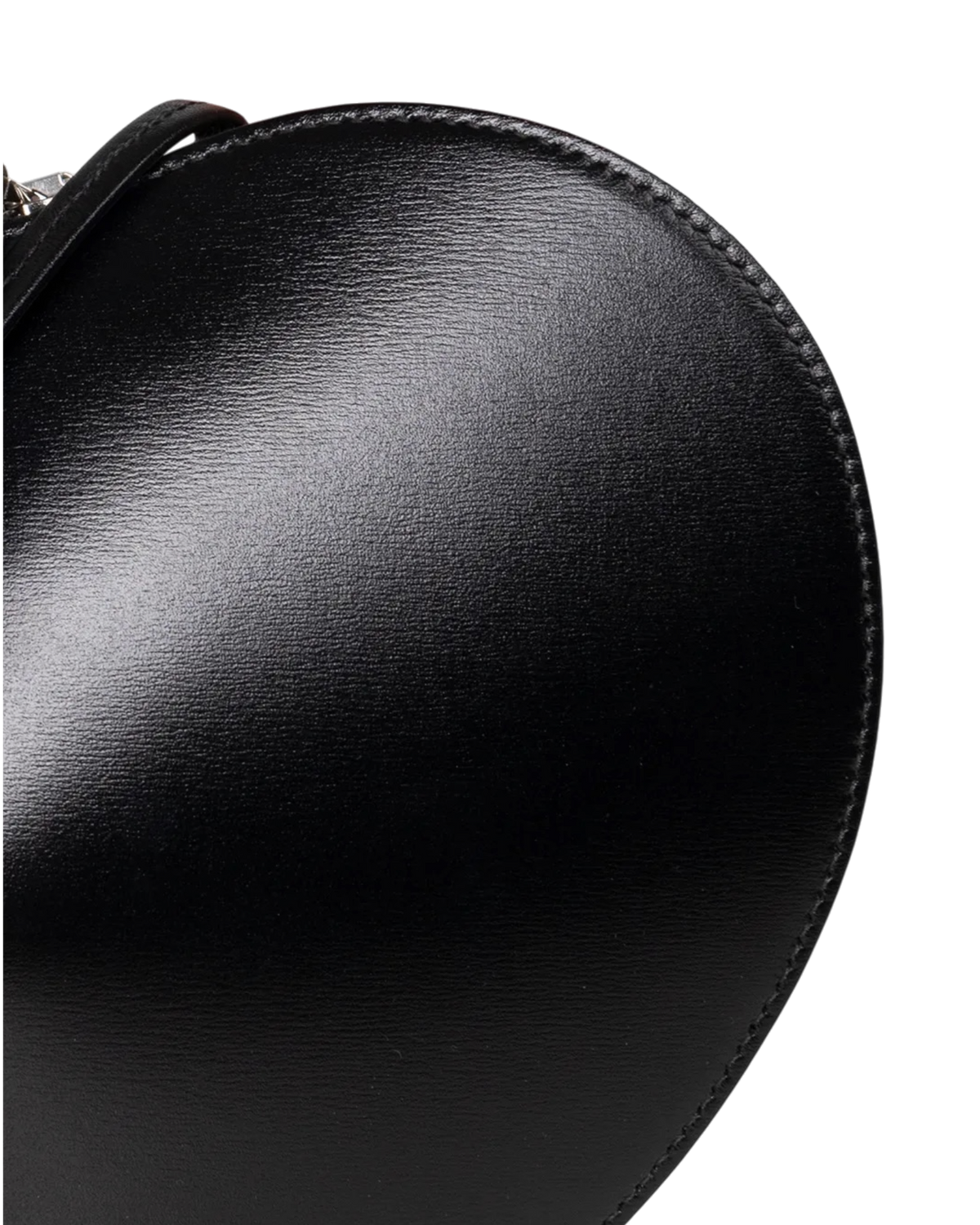 Alaïa Le Coeur leather shoulder bag in black, detail close-up of the glossy textured leather and stitched edge