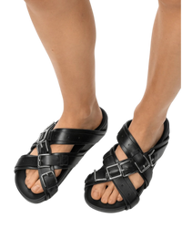 Loewe Type Fussbett sandal in black on model, front view of the pair with crisscross leather straps and silver buckles