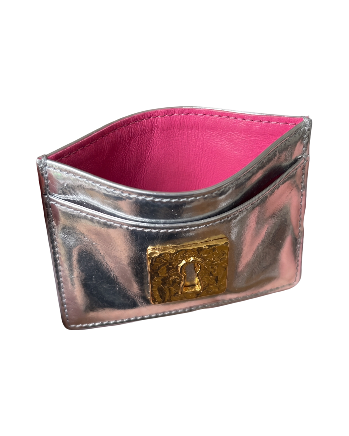 Schiaparelli Keyhole card holder in silver, angled front view open to show the hot pink leather lining and card slots