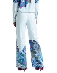 Valentino Garavani Macro Ortensia printed silk flared pants on model, back view of the pale blue flared legs