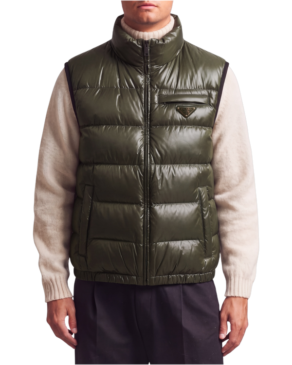 Prada quilted ripstop down gilet in green, front view on model zipped to the funnel neck over a cream knit, triangle logo at the chest pocket