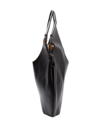 Side profile of the Loewe Paseo tote, showing the slim three-inch depth and the pleated body gathered by the knotted cord