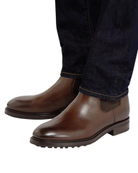 Tom Ford Stuart Chelsea boots in brown calf worn with dark denim, front three-quarter view