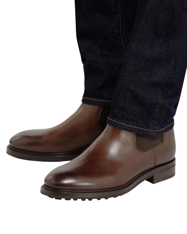 Tom Ford Stuart Chelsea boots in brown calf worn with dark denim, front three-quarter view