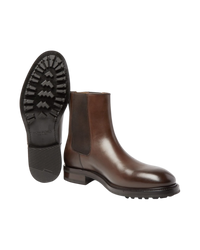 The pair with one boot tipped to show the lugged rubber outsole stamped TOM FORD, Made in Italy, size 11